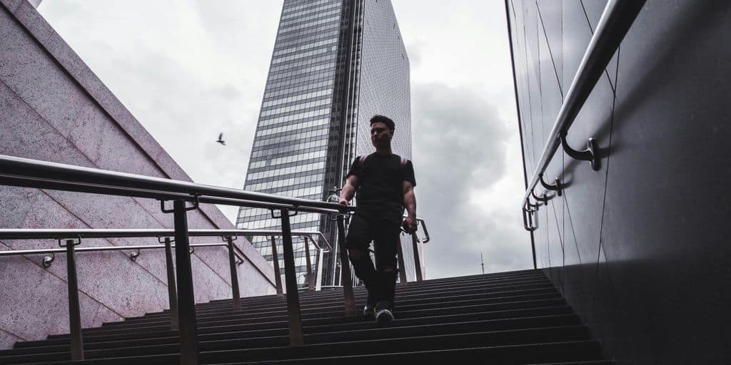 man in black shirt walking along steps during daytime