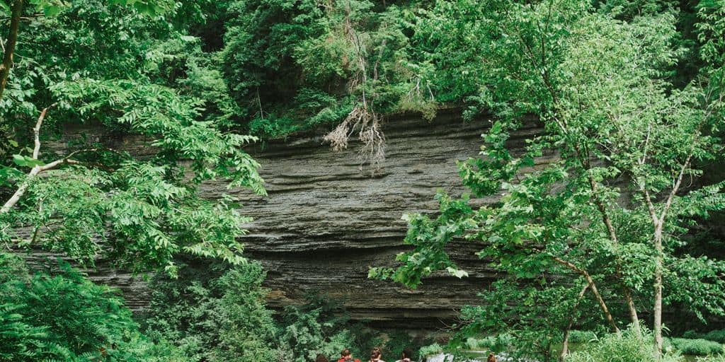 a group of people standing in front of a waterfall