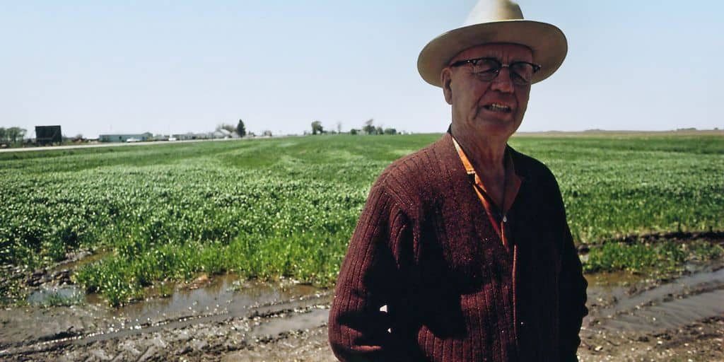 a man wearing a hat standing in a field
