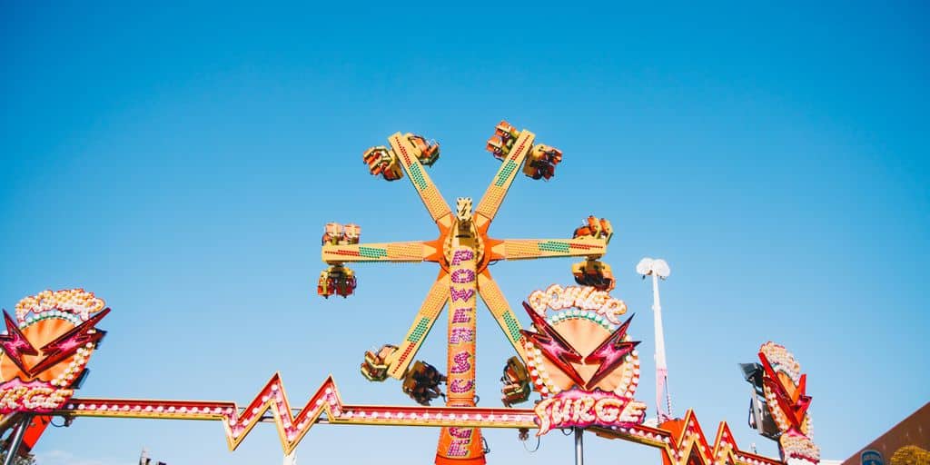 red and yellow metal amusement park ride under blue sky during daytime
